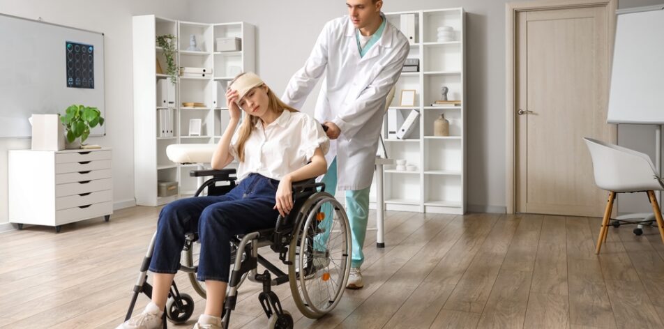 Young woman with brain concussion in wheelchair and doctor at hospital