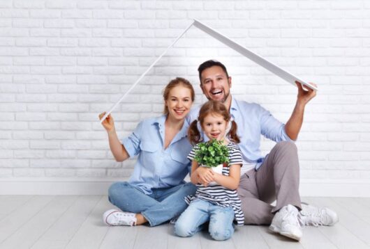 housing a young family. Mother father and child in new house with a roof at empty brick wall