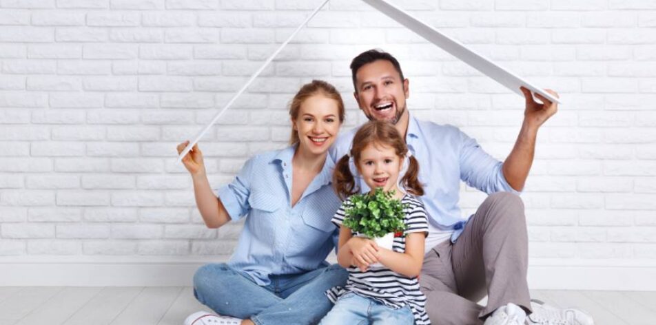 housing a young family. Mother father and child in new house with a roof at empty brick wall