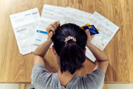 stressed young sitting Asian woman hands holding the head worry about find money to pay credit card debt and all loan bills