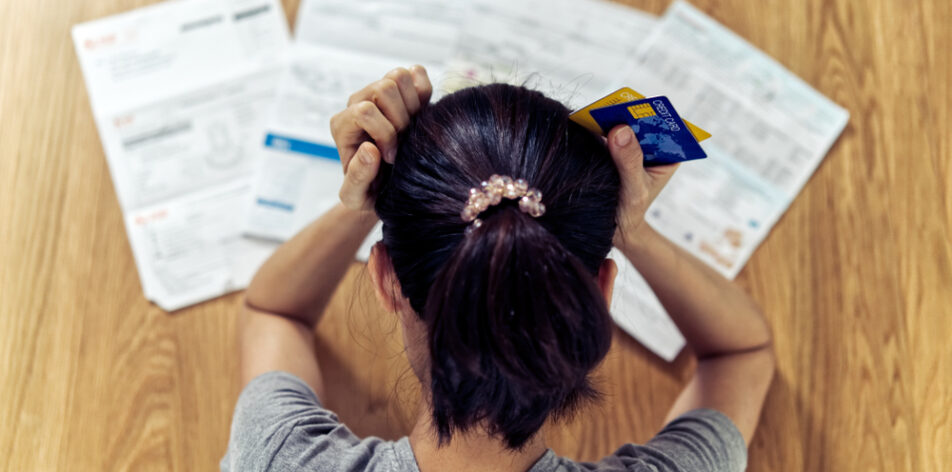 stressed young sitting Asian woman hands holding the head worry about find money to pay credit card debt and all loan bills